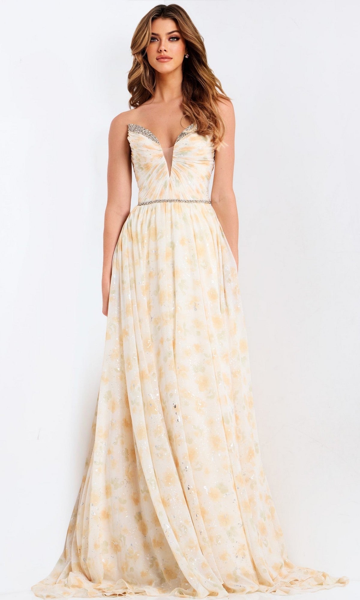 A woman models the Jovani 48139 long prom dress, featuring a strapless chiffon design with a deep V-neckline, jeweled accents at the neckline and waist, and a light floral pattern, posed against a plain white background.
